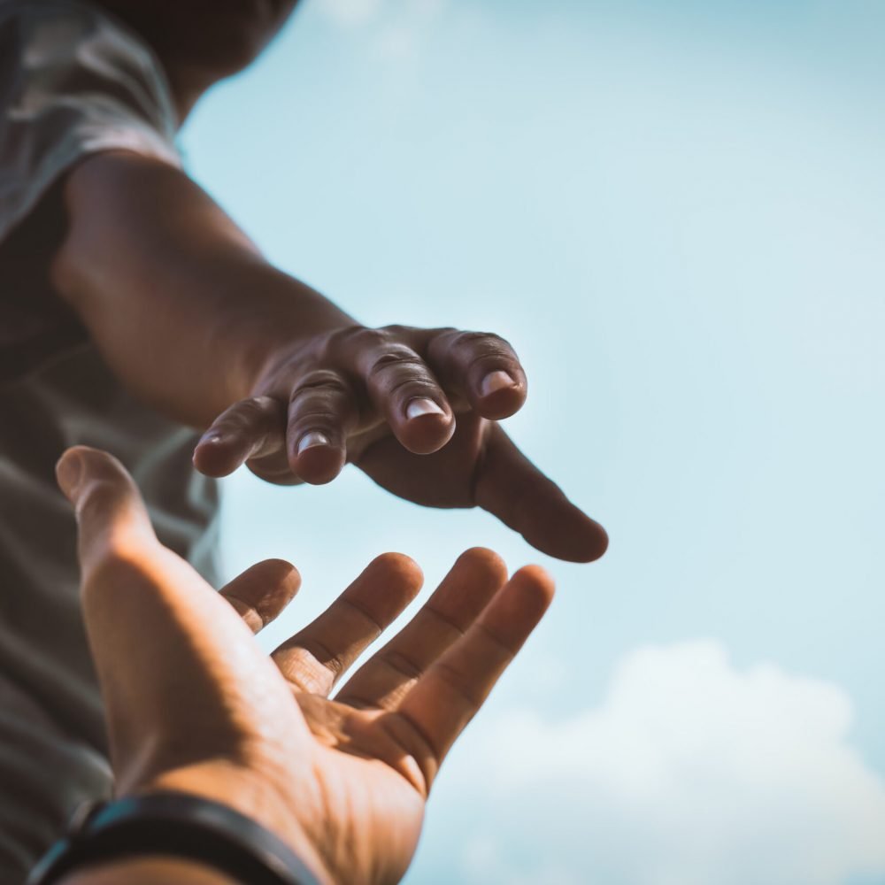 Help Concept hands reaching out to help each other in dark tone